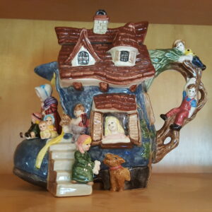 Colorful ceramic teapot shaped like a storybook house with children, representing the Old Woman in a Shoe by Fitz and Floyd, 1995 limited edition.