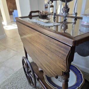 Vintage 1940s Colonial Revival tea cart with glass top, drop-leaf sides, and wooden spoke wheels. main photo